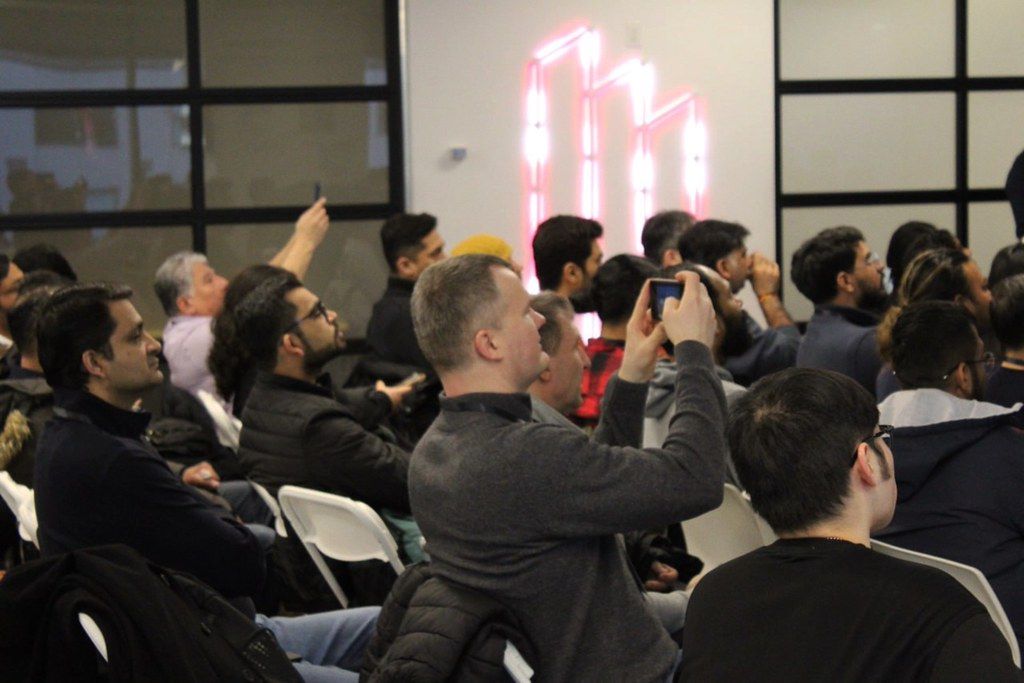 Attendees raising their hands during a session at AgentCon Toronto